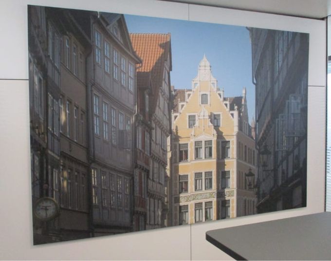 Ein malerischer Blick auf historische Gebäude, die eine schmale Straße säumen und architektonische Details unter einem strahlend blauen Himmel zur Geltung bringen.