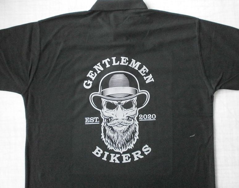 Schwarzes Poloshirt mit der Grafik eines bärtigen Mannes mit Melone, darunter "Gentlemen Bikers" und "EST. 2020" darunter.
